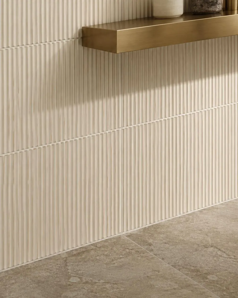 Ribbed cream wall tile detail with brass shelf